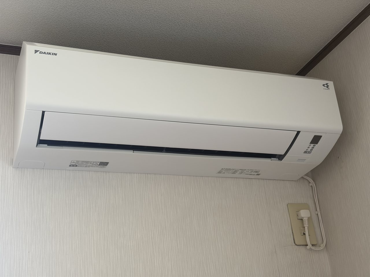 壁に設置が完了した新しいダイキンの室内機 / The newly installed Daikin indoor unit on the wall