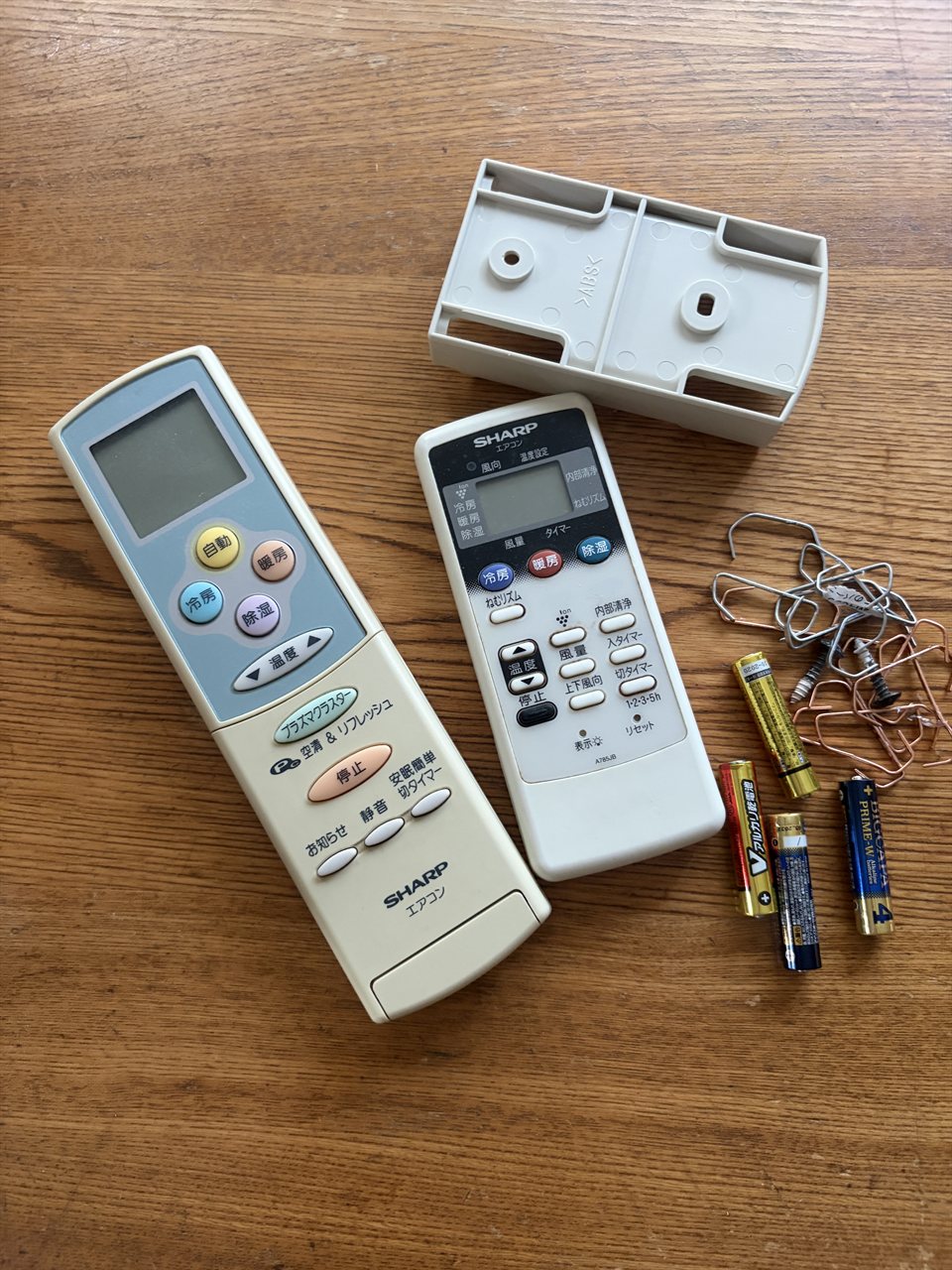 長年使った古いシャープのエアコンのリモコン2つ / Two old Sharp air conditioner remote controls after years of use